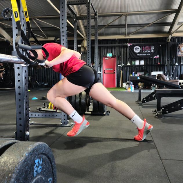 Esra Kangal performing a wall drill against the squat rack. Wall drills help improve sprint speed.